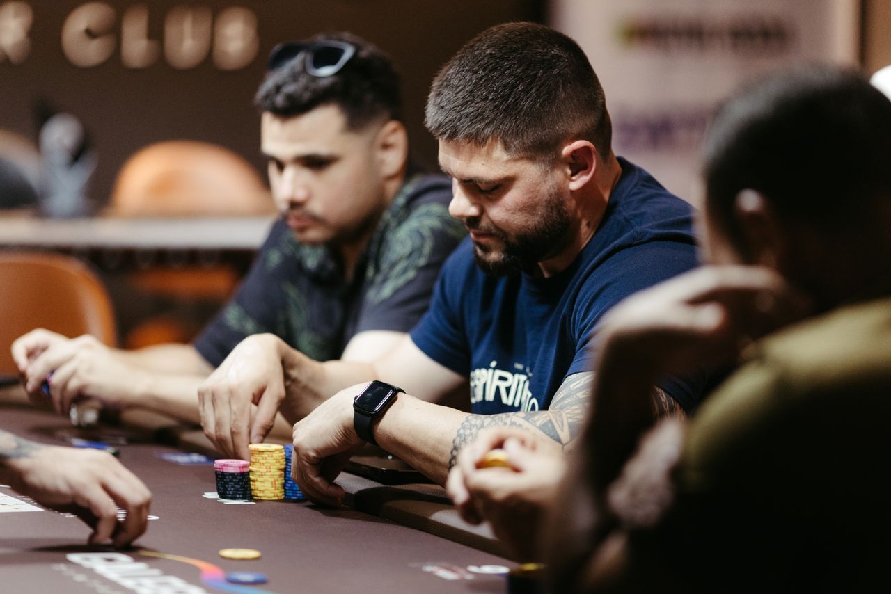 Players focused on a poker game at a casino table, showcasing intense strategies and concentration.